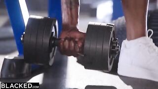 Two beautiful girls have fun with two black men in a gym setting