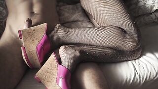 A seductive girl in high heels and pantyhose is making foot jobs