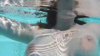 Girl plays with a dildo in the pool, imitating erotic sex