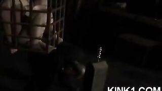 The slave is locked in a cage and obeys all the orders of the mistress