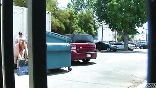A naked girl was photographed having sex behind a garbage tank