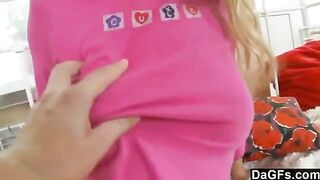 A sweet young blonde plays with her favorite toy on the bed