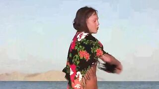 The member shows the girl a beach where nudists can be seen naked