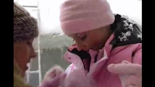 Two girls are having fun and playing with each other in the snow