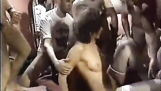 A young whore is throwing herself in a circle with guys