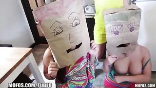 The girls wear bags on their heads while having fun