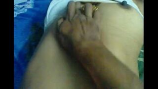 A husband massages the nipples of his wife, showcasing sensual homemade intimacy