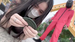 Asian woman participates in a twisted version of the Squid Game and engages in passionate action