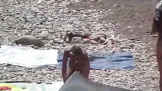 A couple of nudists are having fun on the beach without clothes