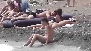 A couple of nudists are having fun on the beach without clothes