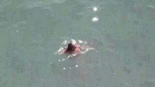 A couple enjoys intimacy without any clothes on the sea