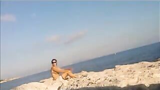 A sexy girl is basking in the sun naked on the beach