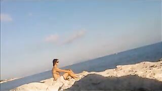 A sexy girl is basking in the sun naked on the beach
