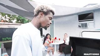 A black guy has sex with a girl at the BBQ in the street