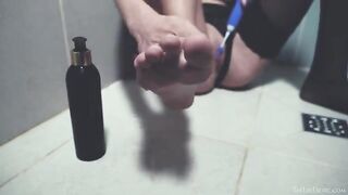 In the shower, a girl plays with her pussy using a toy